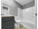 Bathroom featuring modern gray vanity, white fixtures, and a shower-tub combination at 3146 Leyland Ct, Decatur, GA 30034