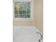 Clean and modern white bathtub with chrome fixtures and a large window with blinds at 3146 Leyland Ct, Decatur, GA 30034