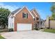 Elegant brick home with a two-car garage, manicured lawn, and inviting front entrance at 315 Hembree Grove Trce, Roswell, GA 30076