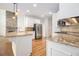 Open kitchen with granite counters, stainless appliances, stone backsplash, and hardwood floors at 315 Hembree Grove Trce, Roswell, GA 30076