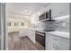 Open-concept kitchen boasts new stainless steel appliances and a stylish gray backsplash at 315 Hembree Grove Trce, Roswell, GA 30076