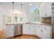 Bright open kitchen with granite counters, stainless dishwasher, hardwood floors, and large windows at 315 Hembree Grove Trce, Roswell, GA 30076