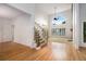 Bright living room featuring large windows, a stone fireplace, hardwood floors, and staircase at 315 Hembree Grove Trce, Roswell, GA 30076