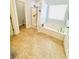 Well-lit bathroom showcasing a tub, tiled floor, and a shower with glass door at 6725 Grove Meadows Ln, Cumming, GA 30028
