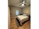 Cozy bedroom with wood floors, ceiling fan, barn door and a comfortable-looking bed at 6725 Grove Meadows Ln, Cumming, GA 30028