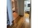 Hallway featuring hardwood flooring, leading to a bathroom with an eye-catching wreath decoration at 6725 Grove Meadows Ln, Cumming, GA 30028