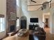 Cozy living room showcasing a stone fireplace, hardwood floors, a comfortable leather sofa, and a view of the staircase at 6725 Grove Meadows Ln, Cumming, GA 30028