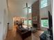 Inviting living room with a stone fireplace, high ceilings, hardwood floors, and ample natural light at 6725 Grove Meadows Ln, Cumming, GA 30028