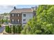 Townhome exterior featuring a brick facade with dark shutters, and green foliage, blending charm with natural beauty at 1914 Forte Ln, Alpharetta, GA 30009