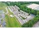 A lovely aerial view of townhomes in a green community near tennis courts and warehouses at 2173 Pebble Beach Dr, Lawrenceville, GA 30043