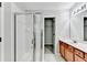 Bathroom featuring a shower, mirrored vanity with wood cabinets and a door leading to a closet at 2173 Pebble Beach Dr, Lawrenceville, GA 30043