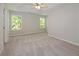 A bedroom featuring neutral carpet, grey walls, two windows, and a ceiling fan at 2173 Pebble Beach Dr, Lawrenceville, GA 30043