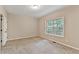 Carpeted bedroom with a large window overlooking the trees at 2173 Pebble Beach Dr, Lawrenceville, GA 30043