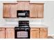 Classic kitchen showcasing wood cabinets and modern black appliances at 2173 Pebble Beach Dr, Lawrenceville, GA 30043