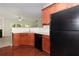 Kitchen with cherry cabinets, tile backsplash, and stainless steel appliances open to the living room at 2173 Pebble Beach Dr, Lawrenceville, GA 30043