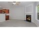 Neutral living room with a fireplace, ceiling fan, and a view into the kitchen at 2173 Pebble Beach Dr, Lawrenceville, GA 30043
