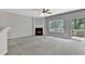 Living room with a cozy fireplace, large window, and access to the patio at 2173 Pebble Beach Dr, Lawrenceville, GA 30043