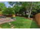 Green backyard with patio, fire pit, wooden fence, and mature trees at 2713 Stillwater Lake Ln, Marietta, GA 30066