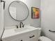 Modern bathroom with a round mirror, black accents and a single sink vanity at 2713 Stillwater Lake Ln, Marietta, GA 30066
