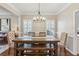 Elegant dining room with stylish chandelier, wood table, and white molding, perfect for gatherings at 2713 Stillwater Lake Ln, Marietta, GA 30066