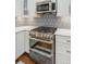 Modern kitchen featuring stainless steel double oven, gas range, microwave, white cabinets, and tiled backsplash at 2713 Stillwater Lake Ln, Marietta, GA 30066