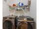 Laundry room with dual Samsung washer and dryers and a shelf for storage at 2713 Stillwater Lake Ln, Marietta, GA 30066