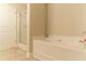 Bathroom featuring a soaking tub, glass-enclosed shower, and tile flooring at 7162 Fringe Flower Dr, Austell, GA 30168