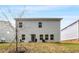 View of the backyard with a rear view of the gray siding on a two story home with outdoor seating at 9007 Jim Purcell Dr, Covington, GA 30014