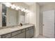Bright bathroom features a double vanity with granite countertop and a large mirror with modern lighting at 9007 Jim Purcell Dr, Covington, GA 30014