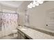 Bathroom with granite countertops, white cabinets, and a shower-tub with shower curtain at 9007 Jim Purcell Dr, Covington, GA 30014