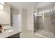 Bathroom featuring double sinks, gray cabinets, and a tiled shower with a glass door enclosure at 9007 Jim Purcell Dr, Covington, GA 30014