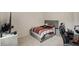 Neutral-toned bedroom with a bed, desk, office chair, and neutral carpeting at 9007 Jim Purcell Dr, Covington, GA 30014