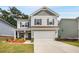 Charming two-story home with a gray exterior, covered porch, and two-car garage at 9007 Jim Purcell Dr, Covington, GA 30014