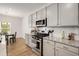 Modern kitchen featuring stainless steel appliances, granite counters, gray cabinets, and eat-in table at 9007 Jim Purcell Dr, Covington, GA 30014