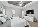 Primary bedroom with tray ceiling, ceiling fan, and ensuite bathroom at 2939 Woodward Down Trl, Buford, GA 30519