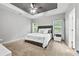 Bedroom with tray ceiling, ceiling fan, and windows at 2939 Woodward Down Trl, Buford, GA 30519