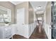 Inviting hallway with hardwood floors, white wainscoting, and modern lighting fixtures at 2939 Woodward Down Trl, Buford, GA 30519