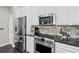 Modern kitchen featuring stainless steel appliances, white cabinets, and dark countertops at 2939 Woodward Down Trl, Buford, GA 30519