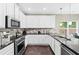 Well-equipped kitchen with stainless steel appliances and a large island with bar seating at 2939 Woodward Down Trl, Buford, GA 30519