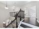 View of staircase with dark wood railing and open floor plan to kitchen below at 2939 Woodward Down Trl, Buford, GA 30519