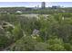 Aerial view of a quaint house nestled amidst trees with the city skyline in the background, showcasing its serene location at 4404 Old Georgetown Trl, Atlanta, GA 30338
