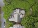 An aerial view shows the roof of a beautiful house surrounded by lush greenery and a small outdoor seating area at 4404 Old Georgetown Trl, Atlanta, GA 30338