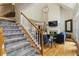 Bright, open living room with a soaring ceiling, fireplace, and staircase with carpet runner at 4404 Old Georgetown Trl, Atlanta, GA 30338