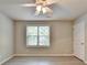 A bright bedroom featuring vinyl flooring, a ceiling fan, and a window at 4885 Maristone Landing Way, Cumming, GA 30040