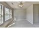 A carpeted bedroom with a ceiling fan and three bright windows at 4885 Maristone Landing Way, Cumming, GA 30040