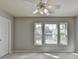 A carpeted bedroom features a ceiling fan and three windows letting in natural light at 4885 Maristone Landing Way, Cumming, GA 30040