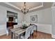 Elegant dining room featuring a rustic table, tray ceiling, and neutral colors at 4885 Maristone Landing Way, Cumming, GA 30040