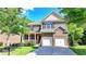 Two-story brick home featuring a manicured lawn, an attached garage, and a covered porch at 4885 Maristone Landing Way, Cumming, GA 30040