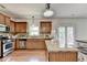 Well-lit kitchen with stainless steel appliances, wood cabinets, and granite countertops at 4885 Maristone Landing Way, Cumming, GA 30040