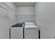 This laundry room features a washer, dryer, and wire shelving for storage at 4885 Maristone Landing Way, Cumming, GA 30040